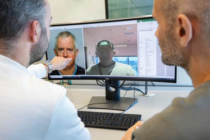 Onderzoekers kijken naar het scherm waar twee afbeeldingen van mogelijk dezelfde man op staan.