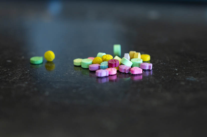 Verschillende gekleurde pillen op een hoopje bij elkaar.