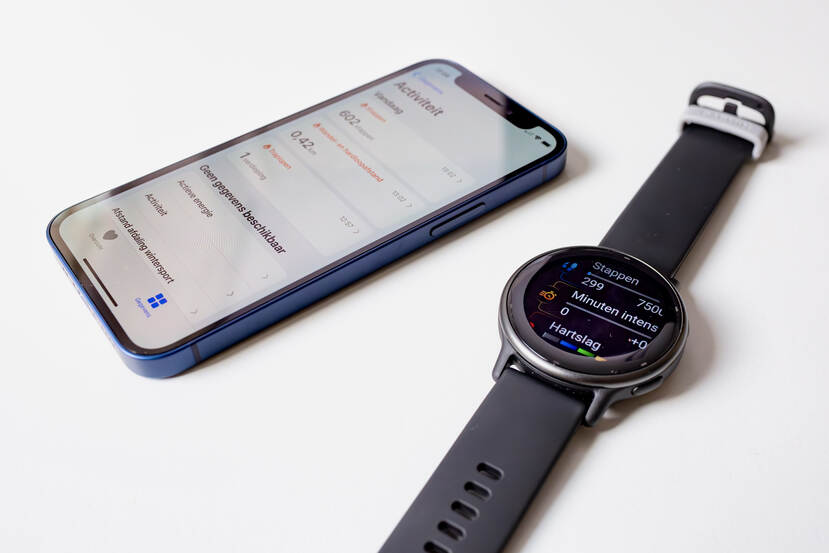 Een smartphone en smartwatch tonen het aantal getelde stappen